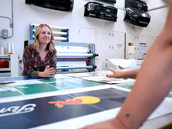 A CG Detroit designer and production lead reviewing artwork together