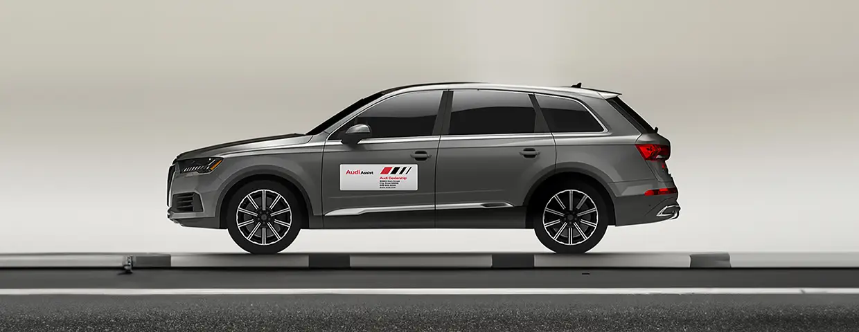 Side view of an Audi SUV with a removable Audi Assist magnet panel on the driver's door.
