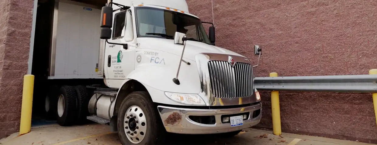 An FCA wrapped semi truck with leaving a garage