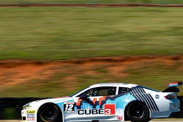 A CUBE3 race car at speed on track in full livery