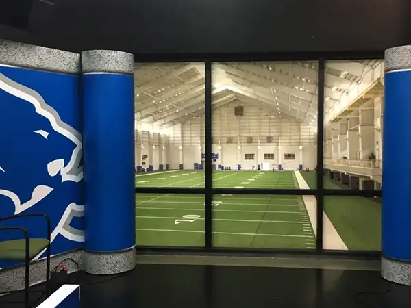 Large, bold interior wall graphics displaying the Detroit Lions football team branding at the entrance of the team practice facility.