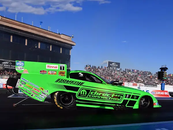 Bright green funny car on the track with custom Mopar Direct Connection motorsports wrap created and installed by CG Detroit.